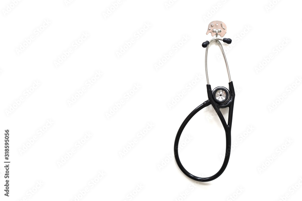 A black stethoscope, medical equipment for physical exam hanging on the white wall A black stethoscope, medical equipment for physical exam hanging on the white wall
