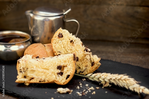 Chocolate panettone and coffe on rustic table photo