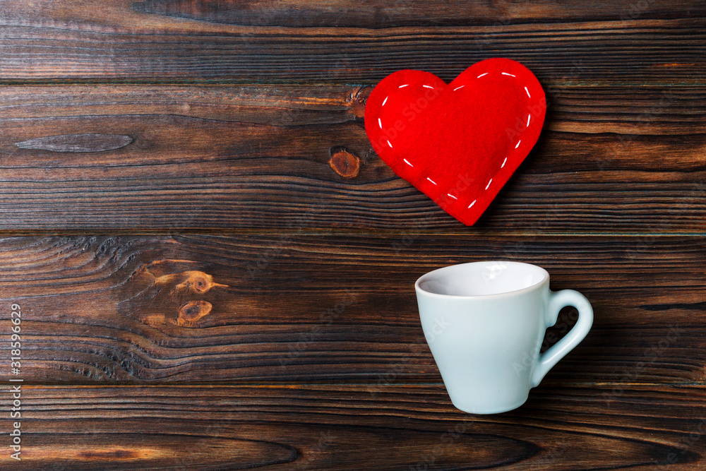 Top view of a cup and red hearts falling out from it on wooden background. Happy Valentine's Day concept Top view of a cup and red hearts falling out from it on wooden background. Happy Valentine's Day concept