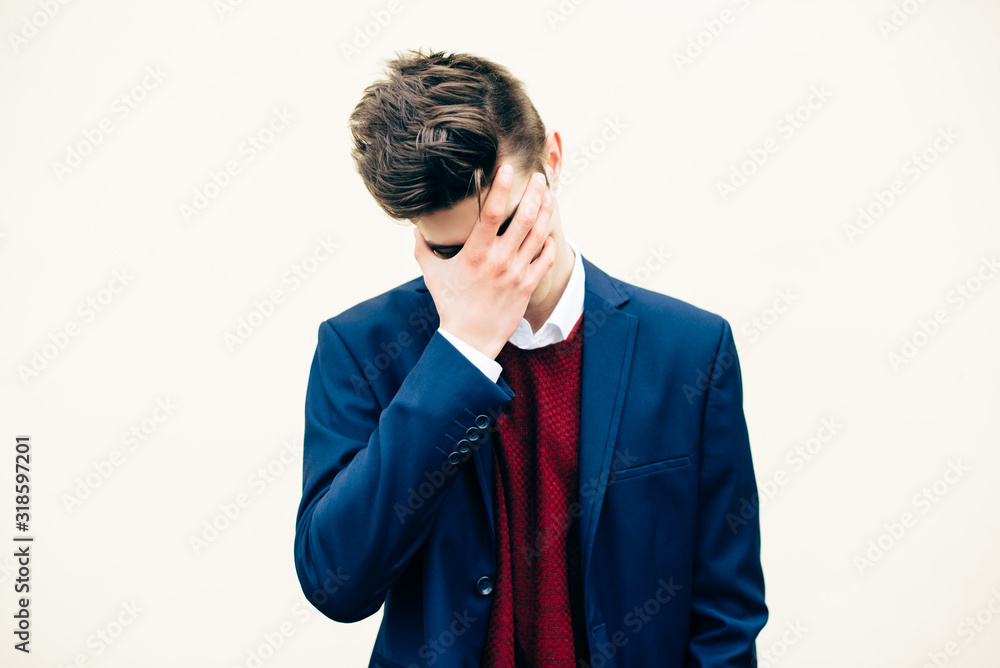 Young man with stylish haircut, in suit, making facepalm gesture isolated on white background. Young man with stylish haircut, in suit, making facepalm gesture isolated on white background.