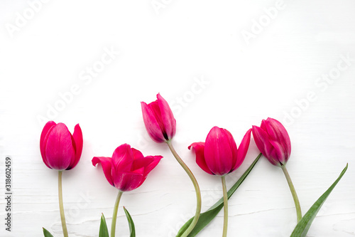Bouquet of pink tulips on white wooden background, top view