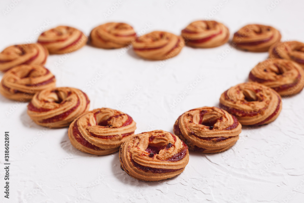 Shortbread cookies with berry jam close-up on a white background arranged in the form of a heart Shortbread cookies with berry jam close-up on a white background arranged in the form of a heart