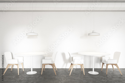 Tables in stylish white industrial style cafe