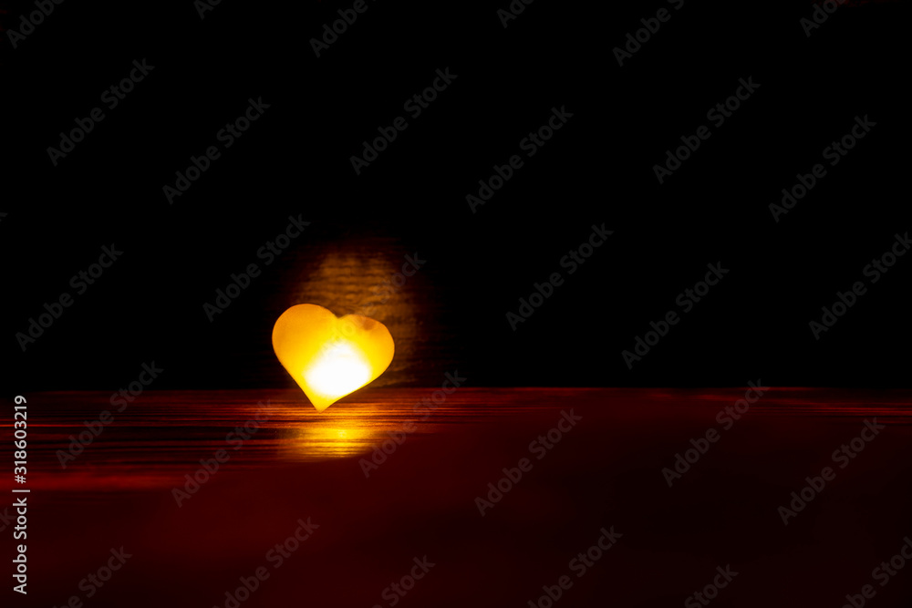 One glowing yellow heart on a dark background.