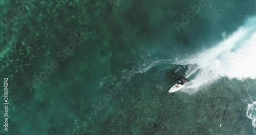 Top down aerial shot on surfers catching waves at the ocean. Bird eye view high on seawater with surfing board at the pacific 