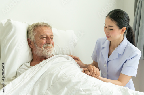 Young nurse take care senior man on a bed, A nurse checking sernior man, Senior man happniess and smiling with nurse, Health care concept © Pornchai