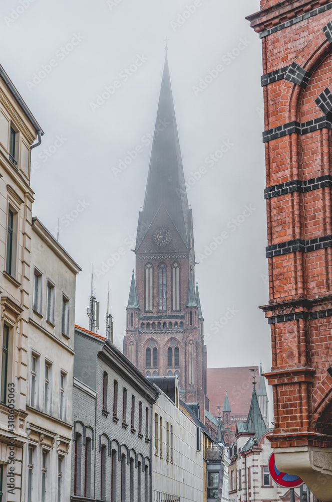 Clock tower of Schwerin Cathedral with heavy fog in Schwerin near Hamburg, Germany