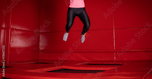 Houng fit happy woman jumping on trampoline in fly park photo