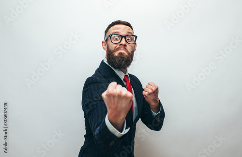 Crazy businessman with beard in trendy formal suit ready for fight over gray background