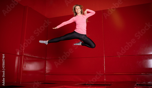 Houng fit happy woman jumping on trampoline in fly park photo