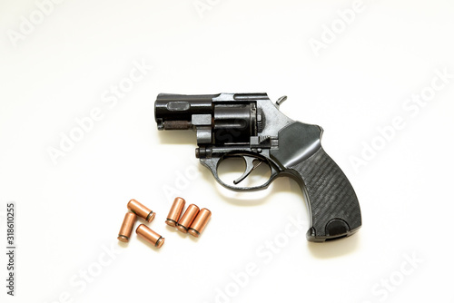 black revolver pistol with cartridges on a white background