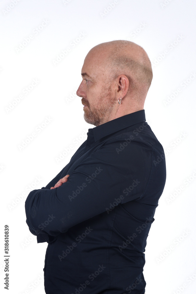portrait of profile of a bald man on white, arms crossed portrait of profile of a bald man on white, arms crossed