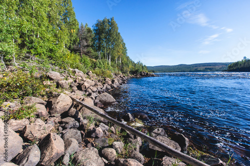 View of Kalix river, Kalixalven, Overkalix locality and the seat in Norrbotten county, Sweden, with forest in sunny summer day, aerial drone view photo