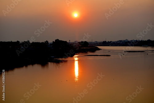 Sunset at the Chao Phraya River at Dechatiwong Bridge, Nakhon Sawan city Thailand. photo