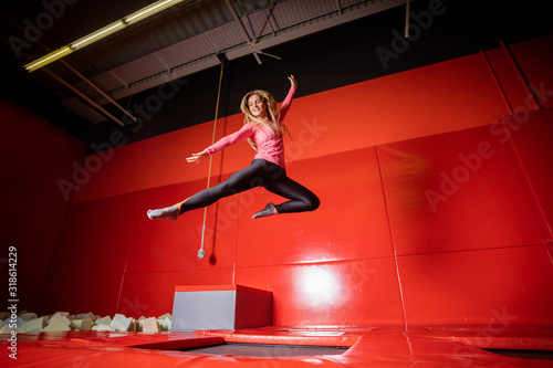 Houng fit happy woman jumping on trampoline in fintess center