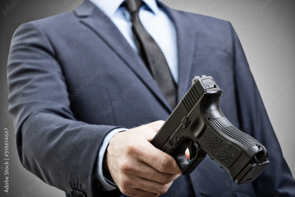 White man holding handgun in hand and trying to pass it to someone White man holding handgun in hand and trying to pass it to someone