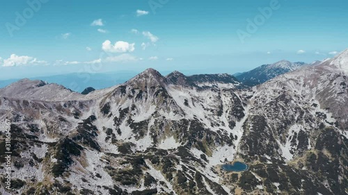 Vihren peak, Todorka peak, Pirin mountains, Bulgaria aerial drone up view on mountain landscape on sunny summer day against blue sky. Nature with undersized shrubs on slopes of mountains, rocky peaks