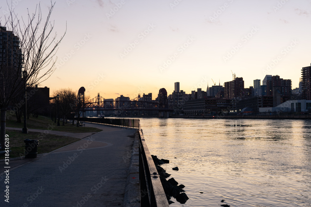 Empty Waterfront at Rainey Park in Astoria Queens New York along the East River with a view of Roosevelt Island and the Manhattan Skyline during Sunset
