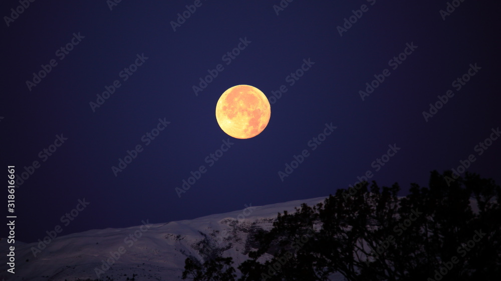 Supermoon full moon over the Jura mountains between Switzerland and France