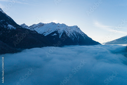 Top of snowy mountains with fog underneath