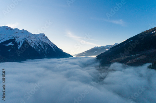 Top of snowy mountains with fog underneath