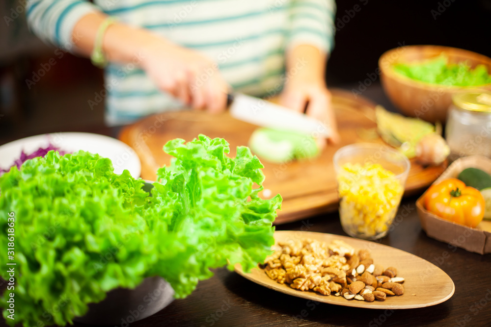 Woman prepares a vegetarian dish with salad, corn, dried fruit and cheese