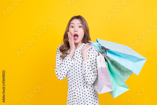 happy asia beautiful smiley woman holding shopping bag with colorful background