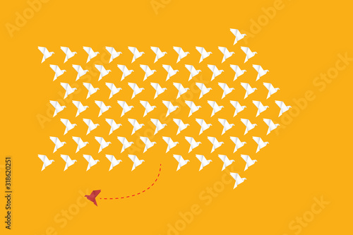 Think differently - One red unique different paper bird flying opposite way of identical white ones. 