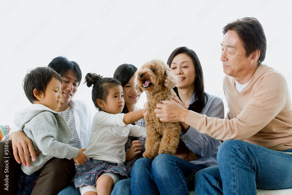 Three generation family sitting with dog on sofa Three generation family sitting with dog on sofa