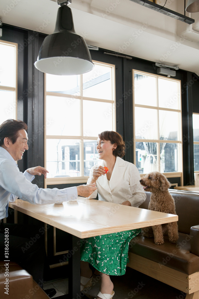 Mature couple with dog relaxing in coffee shop Mature couple with dog relaxing in coffee shop