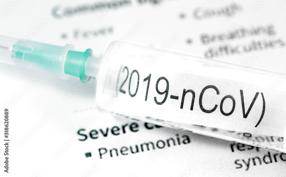 Obraz premium Novel coronavirus (2019-nCoV). Syringe with text (2019-nCoV) on papers background closeup, macro