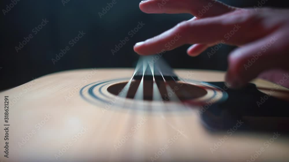 The musician plays with his fingers on the strings of a guitar. The musician plays with his fingers on the strings of a guitar.
