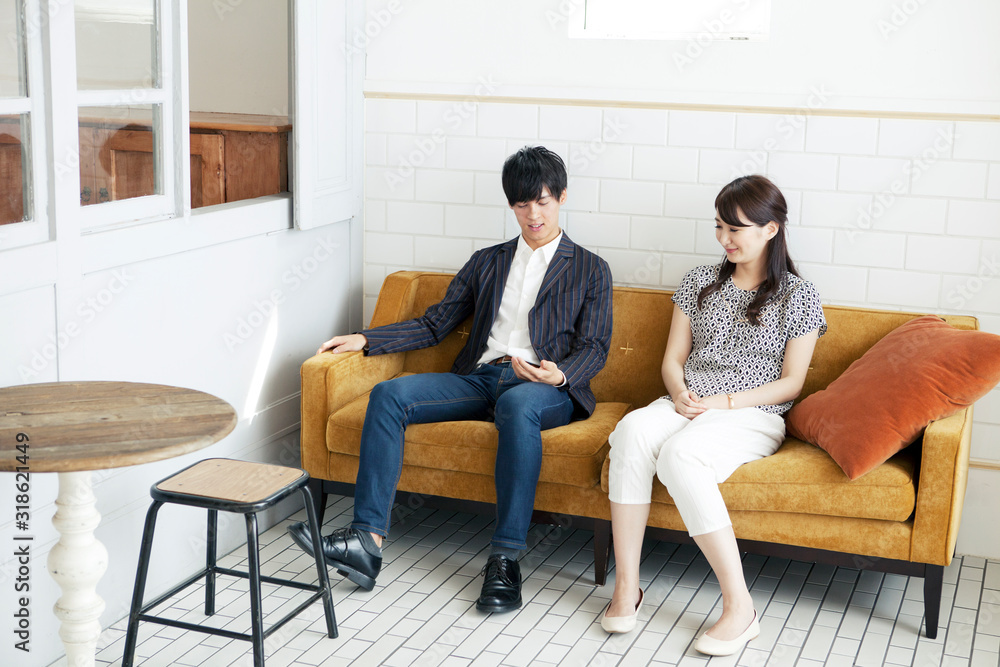 Young man and woman looking at smart phone on sofa Young man and woman looking at smart phone on sofa