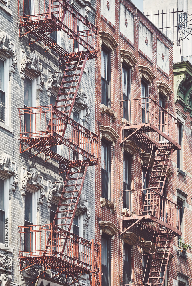 Naklejka premium Manhattan old residential buildings with fire escapes, color toning applied, New York City, USA.