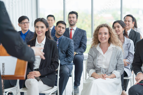 Fototapeta Group of diverse audience  listening to business coach at business meeting and t