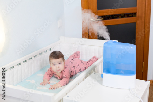 Using humidifier for newborn child comfort breathing, ultrasonic device is in bedroom photo