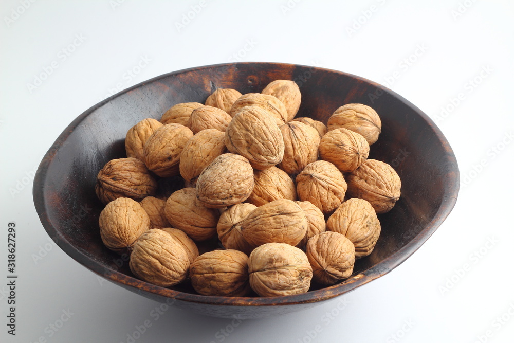 Walnuts isolated on white background. Heap of walnuts isolated on white background. Walnut in a wooden bowl on white background. Walnuts with copy space for text. Walnuts isolated on white background. Heap of walnuts isolated on white background. Walnut in a wooden bowl on white background. Walnuts with copy space for text.