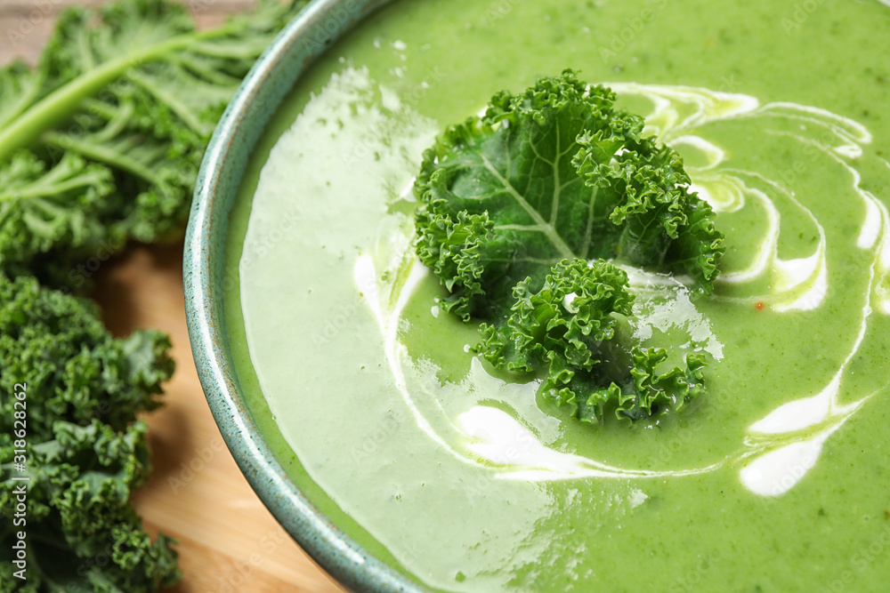 Tasty kale soup with cream on table, closeup Tasty kale soup with cream on table, closeup