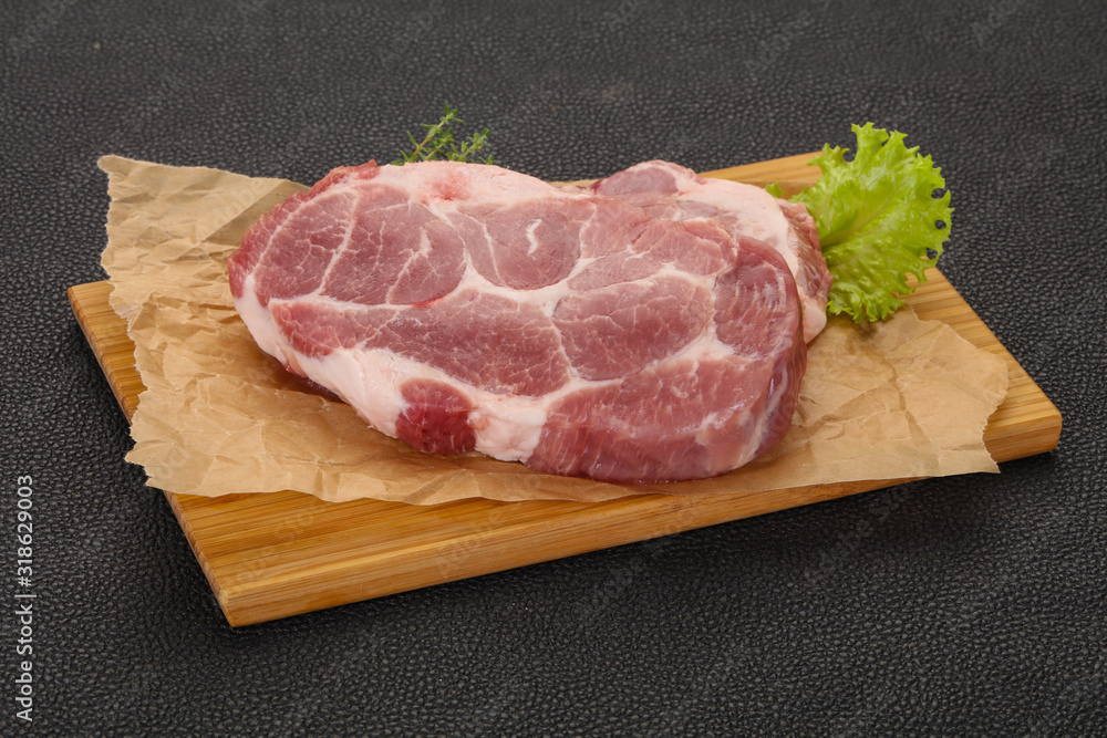 Raw pork steak over wooden board Raw pork steak over wooden board