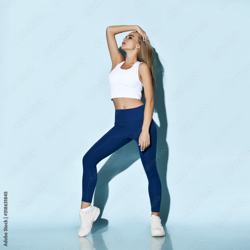 Beautiful sports woman in sport wear after working out sports exercises on pastel color light Beautiful sports woman in sport wear after working out sports exercises on pastel color light