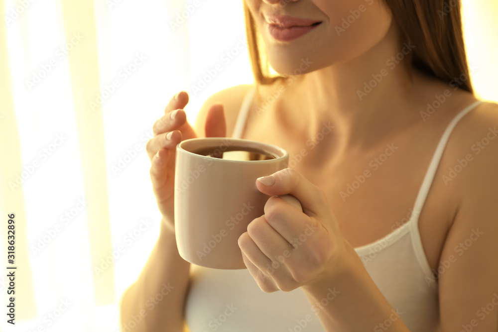 Young woman with cup near window at home, closeup. Lazy morning Young woman with cup near window at home, closeup. Lazy morning