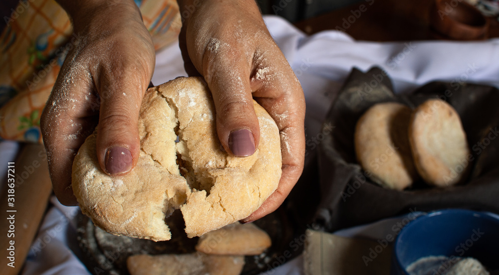 manos de mujer partiendo pan casero recién horneado Stock Photo