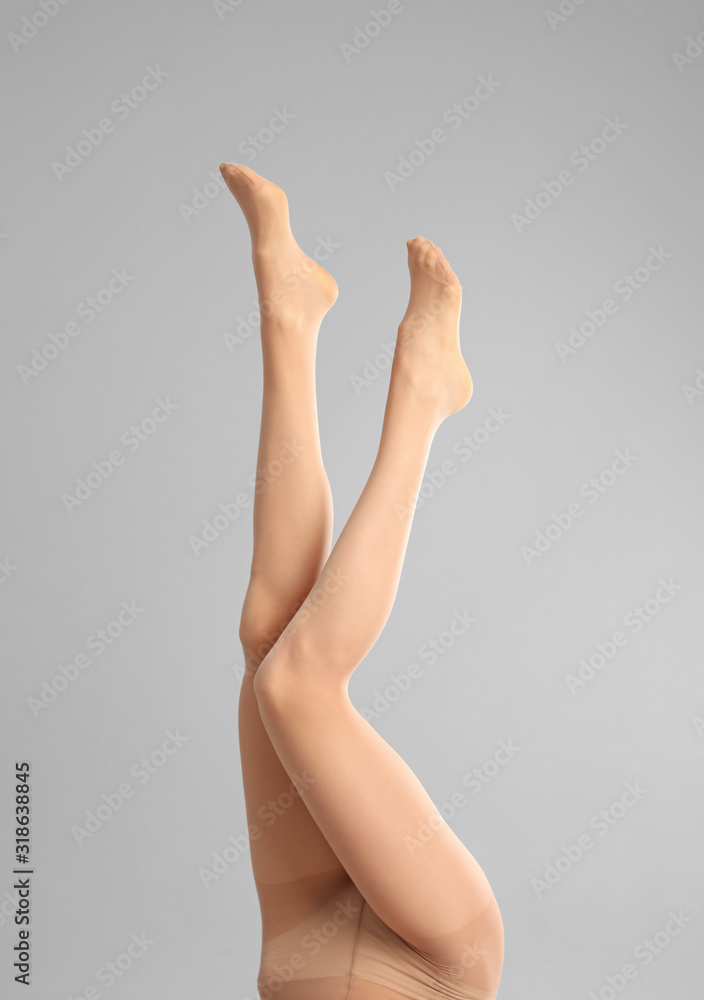 Woman wearing tights on light grey background, closeup of legs Woman wearing tights on light grey background, closeup of legs