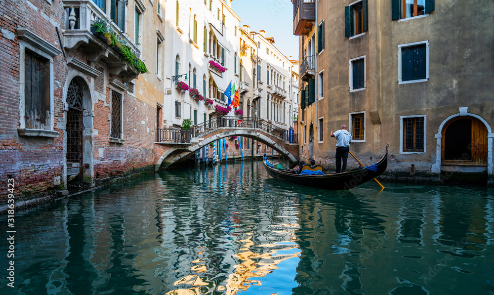 View of the canal with gondolas and old buildings in Venice, Italy. Venice is a popular tourist destination of Europe. Vacation and holidays in Italy and Europe concept.