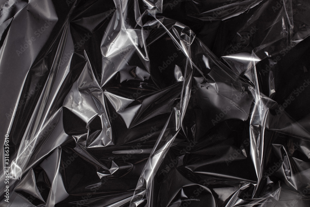Background texture of a polyethylene transparent film on a black background Background texture of a polyethylene transparent film on a black background