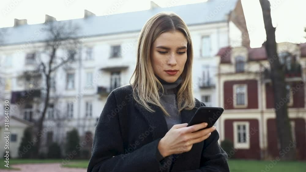 Attractive woman typing Messages on her Smartphone while having a walking in the Street. Having fun and enjoying time outdoor. Pretty brunette with Smartphone in front of Camera. Beautiful girl. Attractive woman typing Messages on her Smartphone while having a walking in the Street. Having fun and enjoying time outdoor. Pretty brunette with Smartphone in front of Camera. Beautiful girl.
