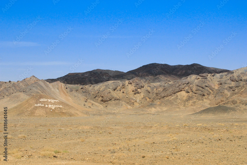 Desert landscape with rocks and geological formations on a hot summer day on the road from Kerman to Mashhad.