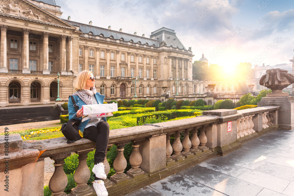 Φωτογραφία A woman reads a city map against the backdrop of the Royal Palace in Brussels, B