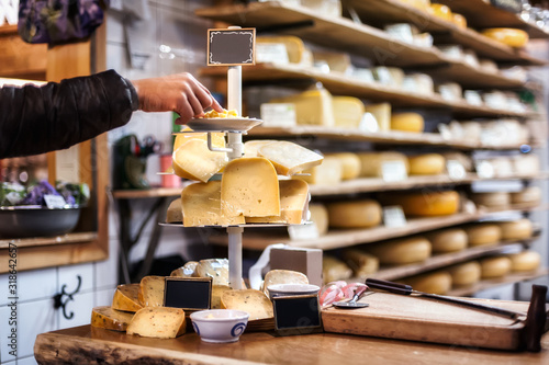 Canvas Print Woman tasting and choosing organic Dutch cheese on the shop