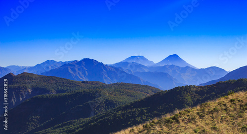 Paisaje que nos entrega la cordillera de los andes con una espectacular vista al volc  n Azul y volc  n Descabezado Grande entre monta  as  bosques y praderas.